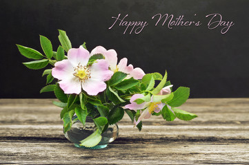 Happy Mothers Day card. Still life with wild roses on grunge background