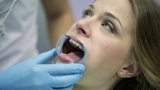 Pretty woman's teeth treatment in dental clinic