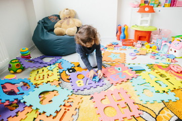 Little girl child playing with numbers puzzle