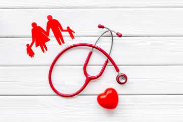 diagnostic and cure of cardiac disease with stethoscope and family paper figures on white background top view