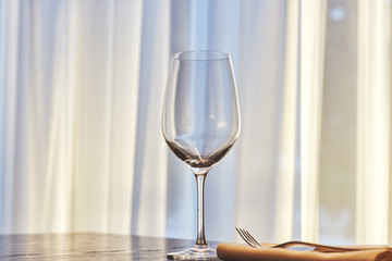 empty wine glass on the table in the restaurant on the background of the window in sunny weather. copy space.