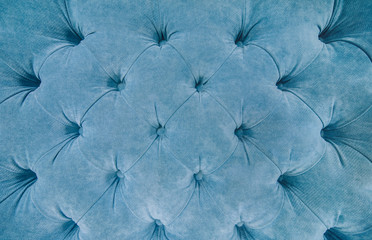Sofa texture background. Blue fabric upholstey texture with buttons. copy space.