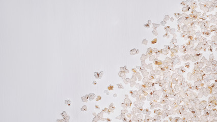 Popcorn on a white wooden background. Background with a plate of popcorn. White background with popcorn.