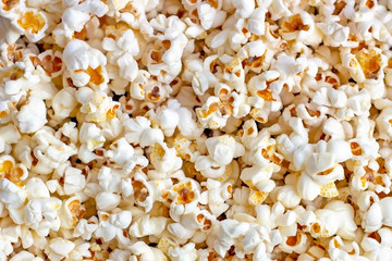 White and yellow fresh salted popcorn texture background. Close up top view food pattern photography