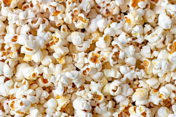 White and yellow fresh salted popcorn texture background. Close up top view food pattern photography