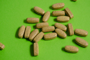 Herbal capsule, Food supplement, Vitamin tablet, Herbal medicine on a green background