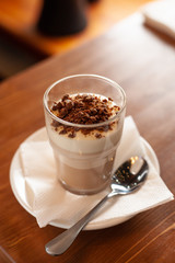 Layered vanilla-chocolate mousse with topping on a wooden rustic table