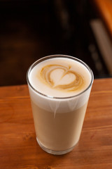 Latte in a glass with latte art on a milk froth