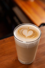 Latte in a glass with latte art on a milk froth