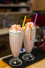Milkshake with whipped cream and caramel topping in a vintage glass