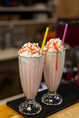 Milkshake with whipped cream and caramel topping in a vintage glass