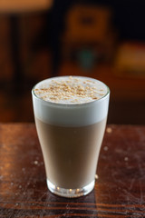 Glass of white milk coffee with puffy foam