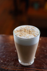 Glass of white milk coffee with puffy foam