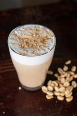 Frothy milk coffee decorated and served with peanuts