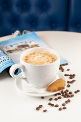 Cup of caramel cappuccino served with a ginger cookie