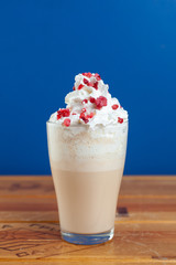 Delicate coffee with milk and whipped cream on a bright blue background