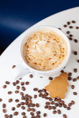 Caramel cappuccino with etching coffee art on froth, served on a white background