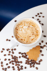 Caramel cappuccino with etching coffee art on froth, served on a white background