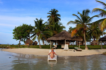 Young beautiful woman enjoying her time and resting in teh private beach of Yandup Island lodge, kuna indians territory, San Blas, Panama.