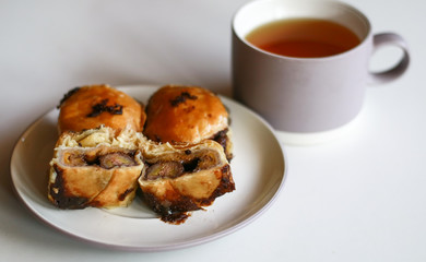 Banana chocolate pastry and a cup of tea on white background. 