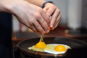 Cracking eggs into pan