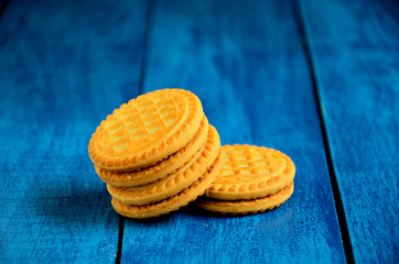 Round biscuits on a blue wooden table background.