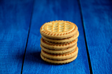 Round biscuits on a blue wooden table background.