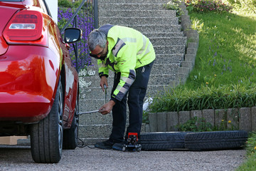 Ein Mann wechselt die Reifen an seinem Auto. Sommerreifenwechsel im Frühling