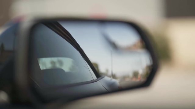 Shot of a side mirror of a Ford Mustang in movement.
