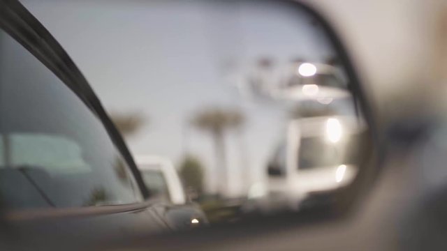 Shot of a side mirror of a Ford Mustang parked along with a blurry background (bokeh).