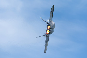 Very close tail  view of a F-22 Raptor, with afterburners on  and condensation trails