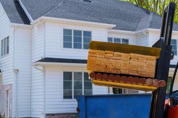 Forklift loading building materials. A stack of boards wood frame and beam construction logistics...