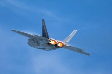   Very close tail  view of a F-22 Raptor, with afterburners on  and condensation trails