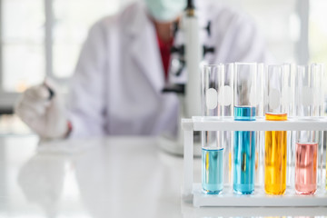 Fototapeta premium A scientist hands working in laboratory with test tube microscope and solutions.
