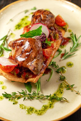 Grilled meat on pita bread on a bright oval plate. Dark wooden background. Restaurant menu