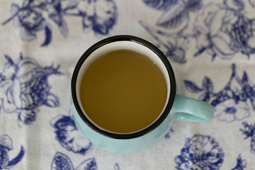 A cup of green tea on white and blue background.