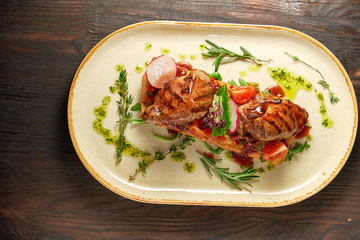 Grilled meat on pita bread on a bright oval plate. Dark wooden background. Restaurant menu