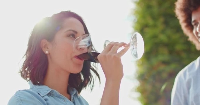 Romantic couple, woman drinking red wine and smiling at sunset warm light. Friends italian trip in Umbria.4k slow motion