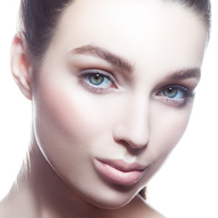 Fototapeta premium Close-up beauty face of sensual young model girl. Perfect skin, looking at camera, blue eyes. Natural nude make-up. Skincare beauty facial treatment, spa, female health concept. White background