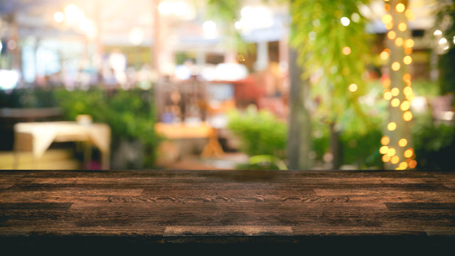 Empty Wood Table Top And Blur Light Reflection On Scene At Restaurant, Pub Or Bar At Night.