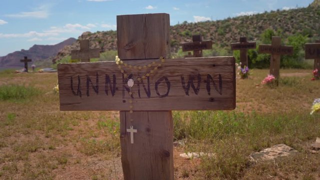Unknown Gravestone with a Crucifix Blowing the an Old West Setting