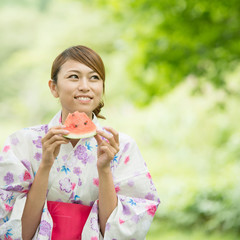 スイカを食べる浴衣姿の女性