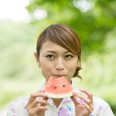 スイカを食べる浴衣姿の女性