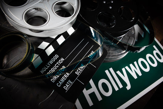 Multiple film reels and a clapboard on a wooden background. Film, Hollywood, entertainment industry objects