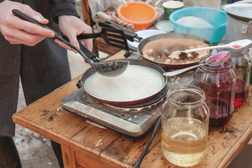 Cooking pancakes outside in the cold. Pancakes are fried in a pan and steam comes out of them. farewell to winter in Shrovetide