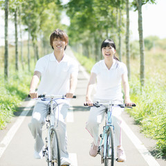 Obraz premium 一本道でサイクリングをするカップル