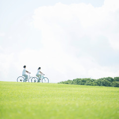 草原で自転車に乗るカップル