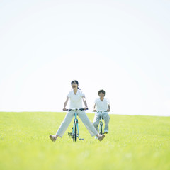 Fototapeta premium 草原で自転車に乗るカップル