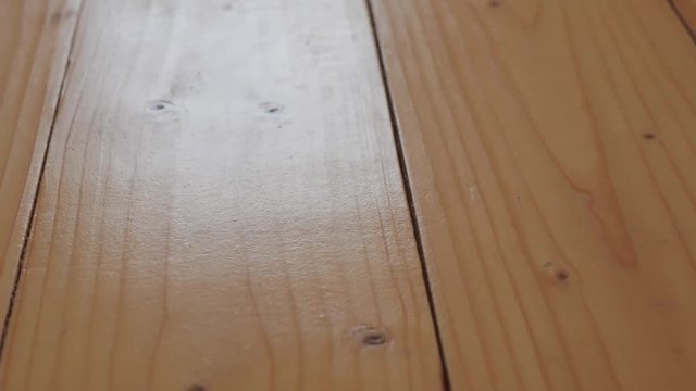 Old , cracked pine wood floor close up, camera movement from right to left.