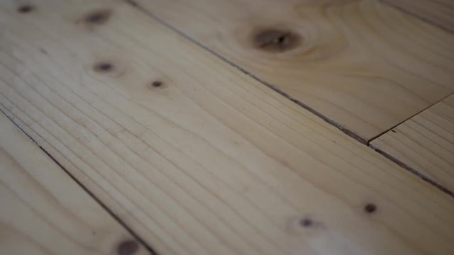 Old , cracked pine wood floor close up, camera movement from right to left.